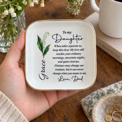 Hand holding personalized To My Daughter long distance jewelry dish with birth flower and name