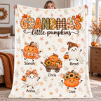Grandma's Little Pumpkins personalized blanket held up in a cozy fall bedroom, with grandkids' names