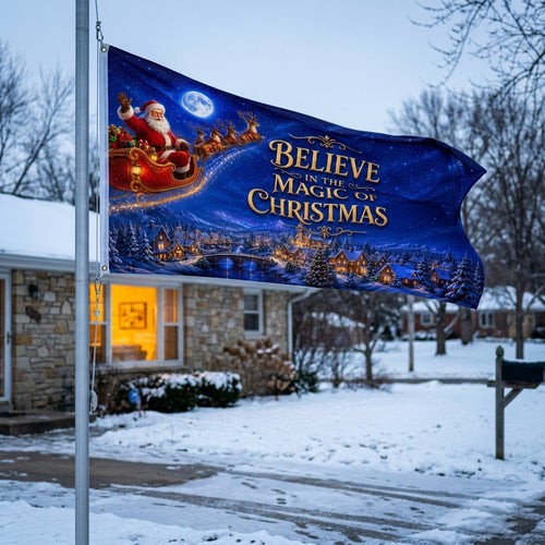 Believe in the Magic of Christmas 3x5 ft flag rippling on a flagpole outside a stone ranch in snow